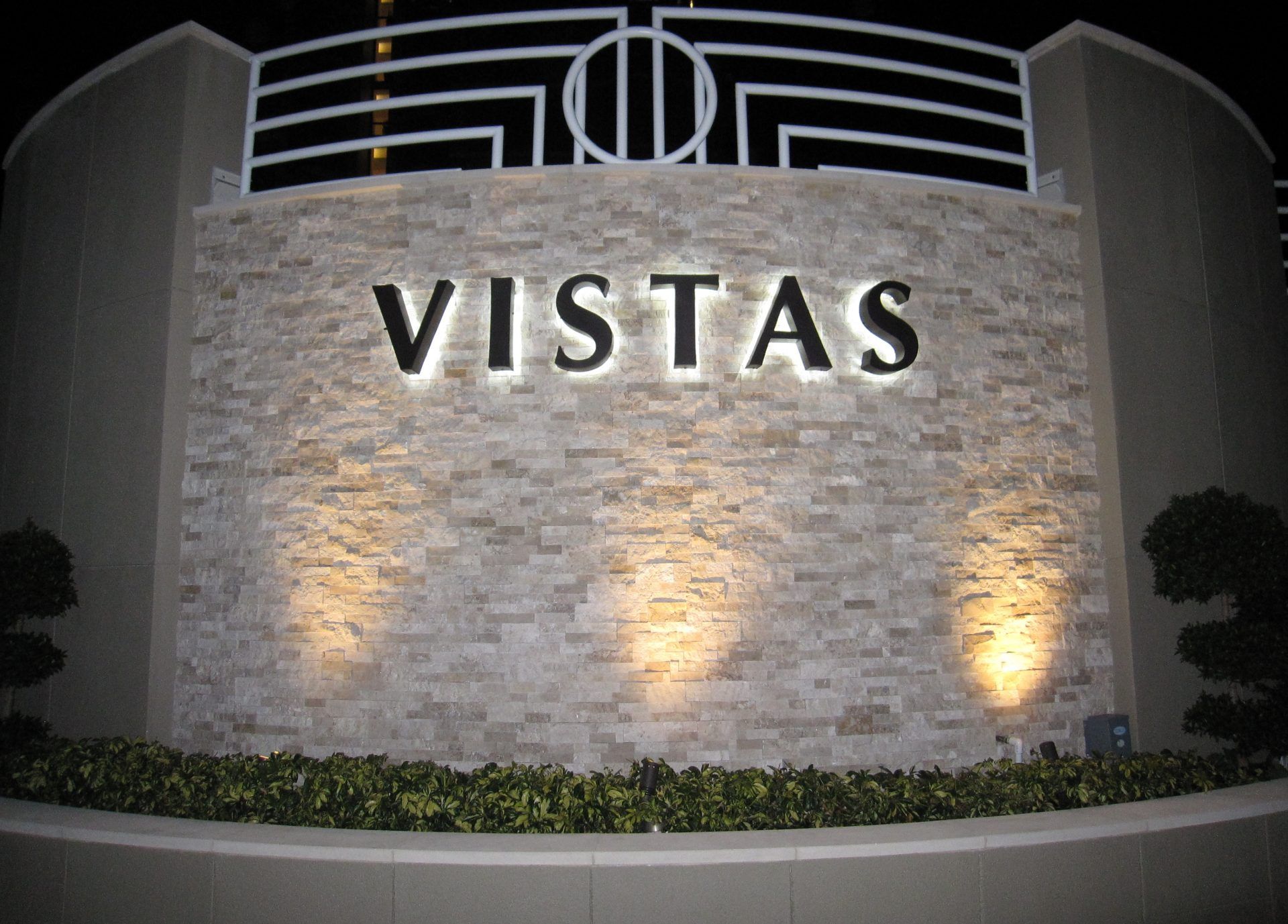 A sign for vistas is lit up at night
