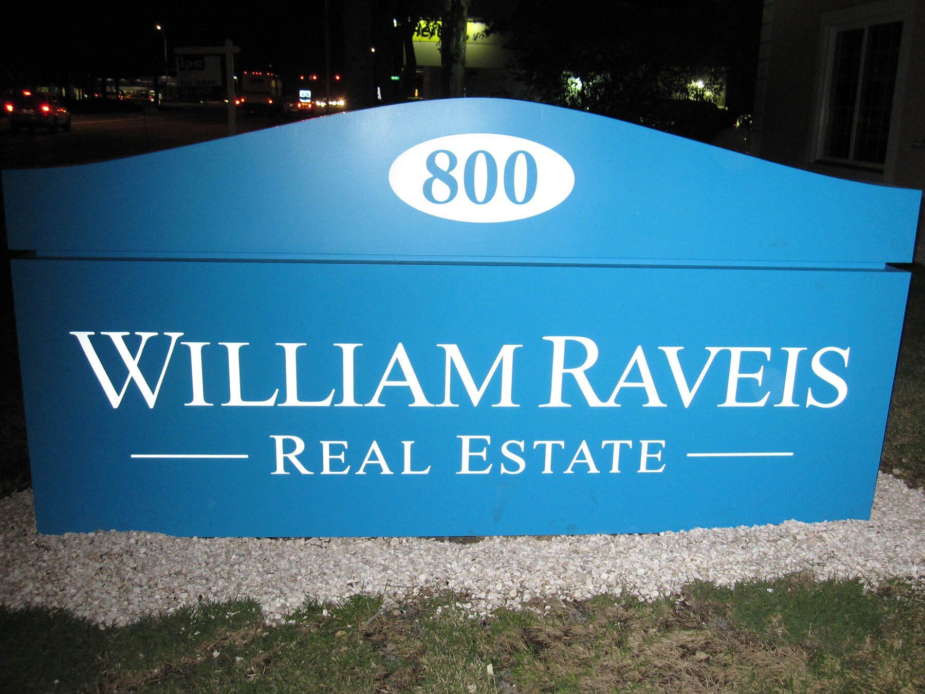 A blue sign for william raveis real estate