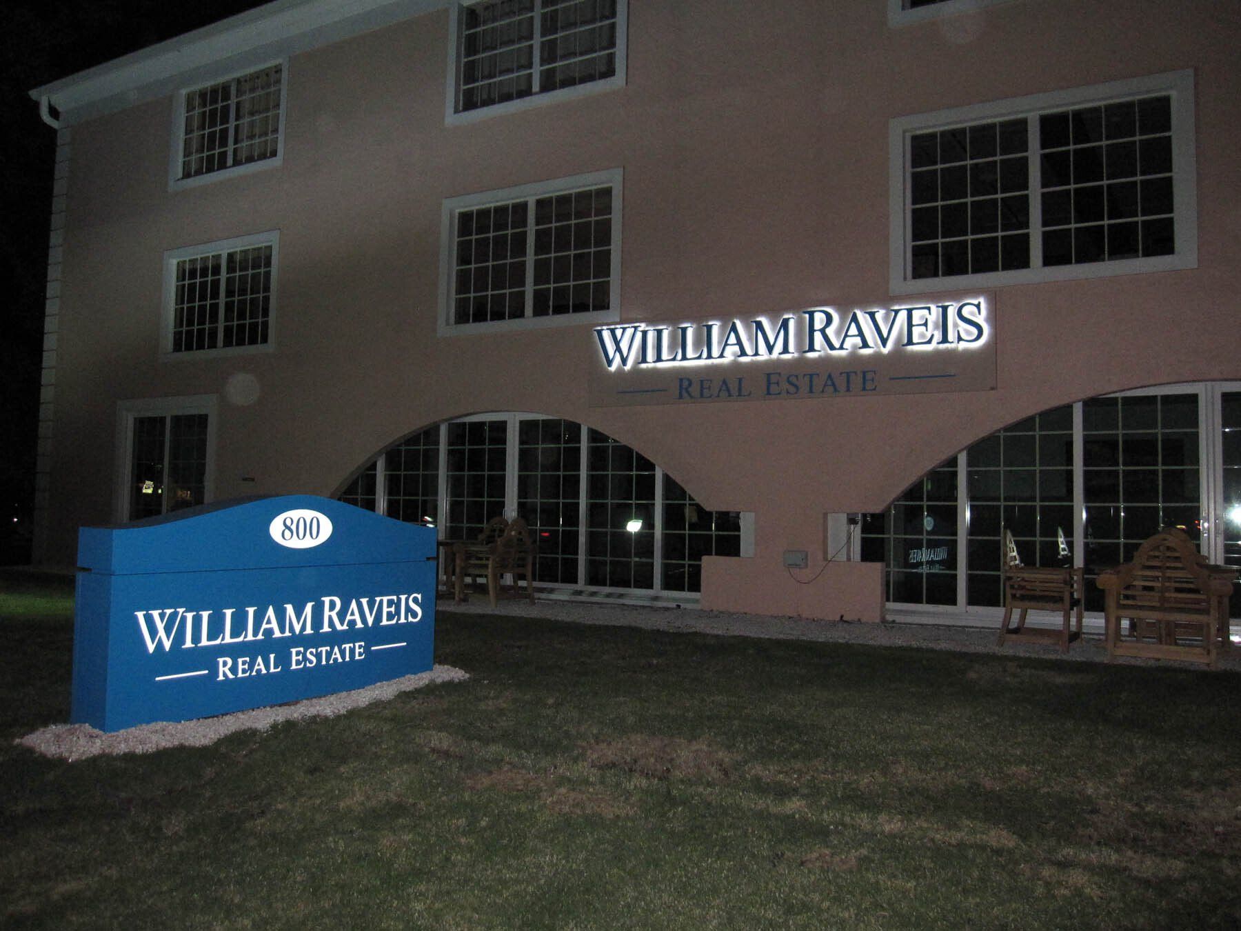 A william ravens real estate sign in front of a building