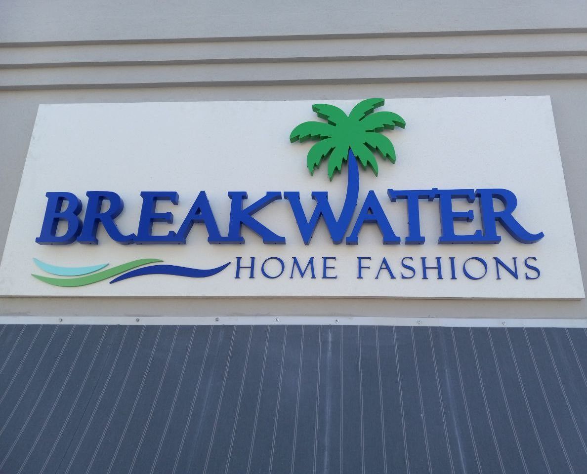 A sign for breakwater home fashions has a palm tree on it
