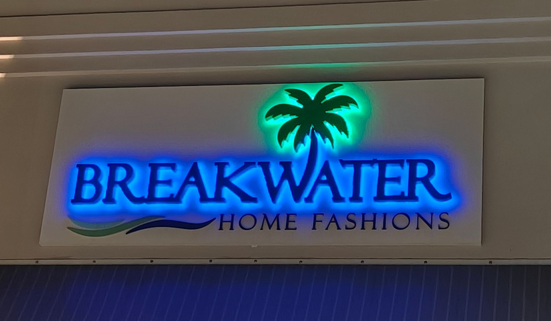 A sign for breakwater home fashions with a palm tree on it