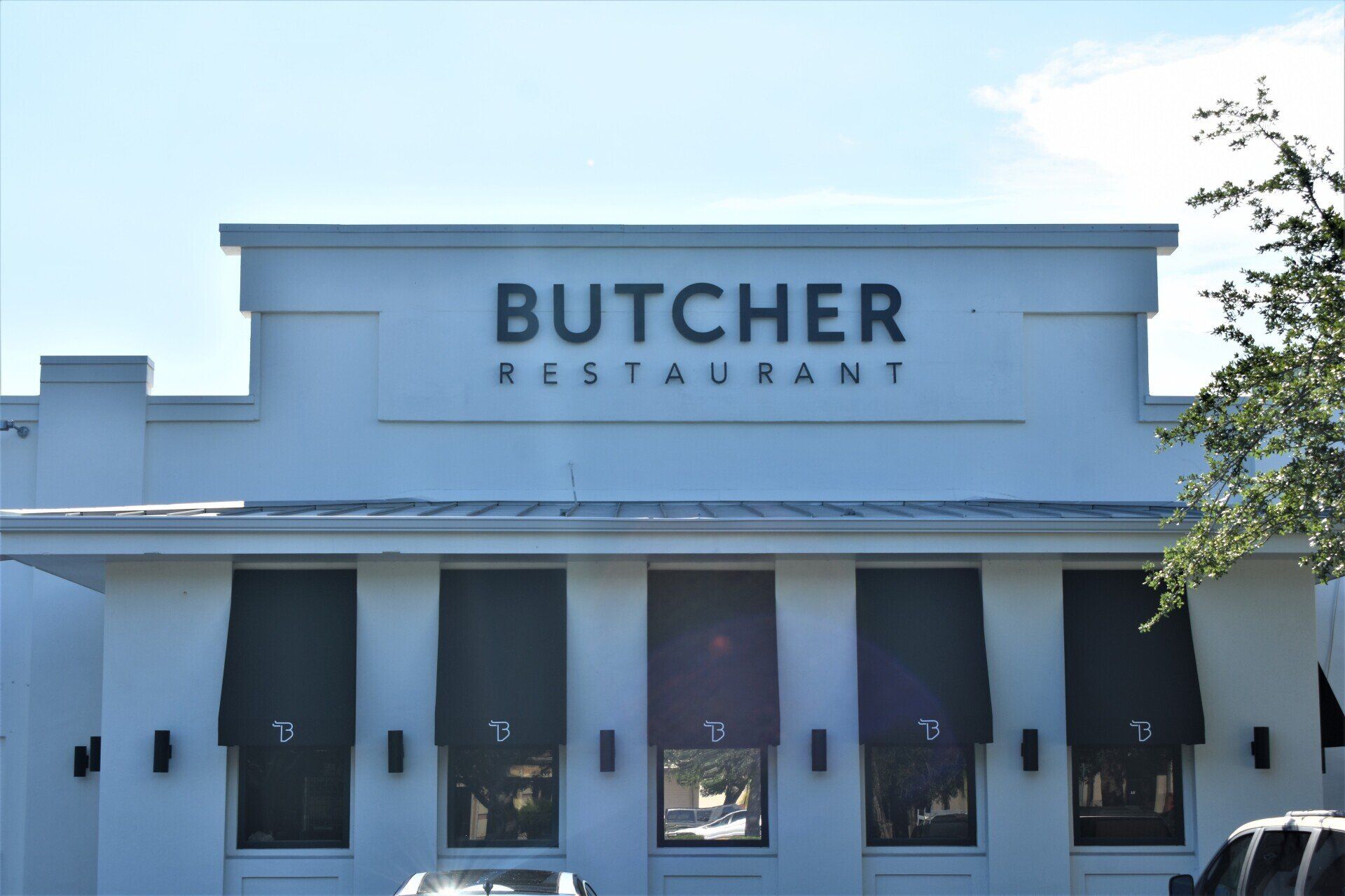 A white building with a sign that says butcher restaurant