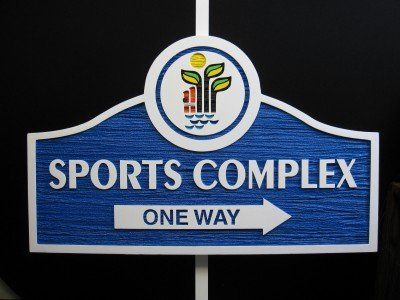 A blue sign that says sports complex one way
