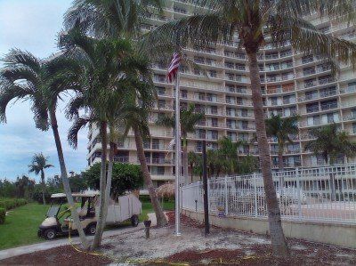 A golf cart is parked in front of a large building.