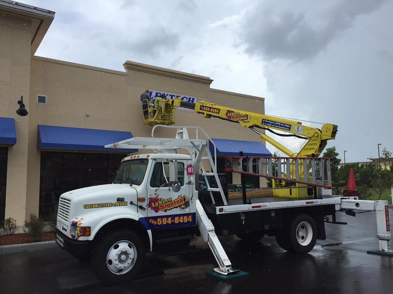 A crane truck is parked in front of a building