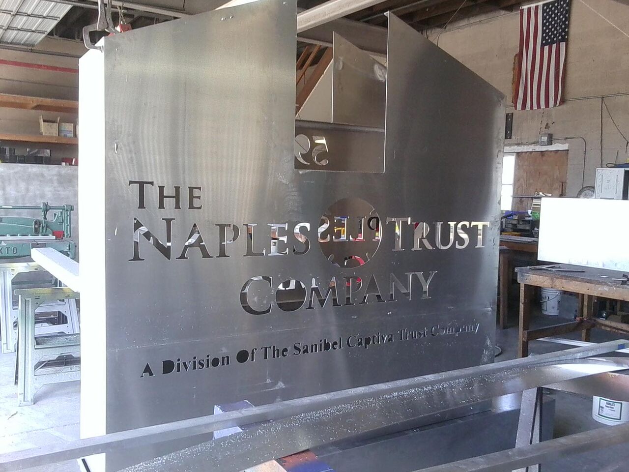 A stainless steel sign for the naples trust company