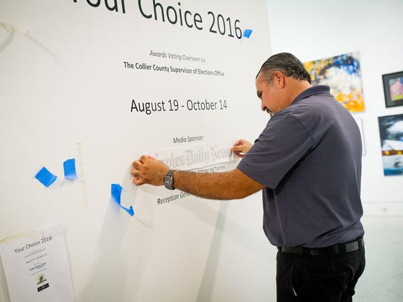 A man is standing in front of a wall that says our choice 2016.