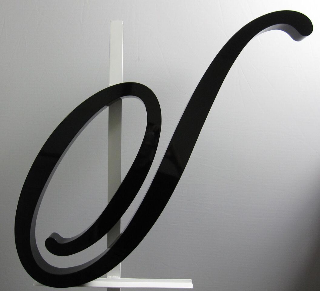 A black letter n is sitting on a white shelf