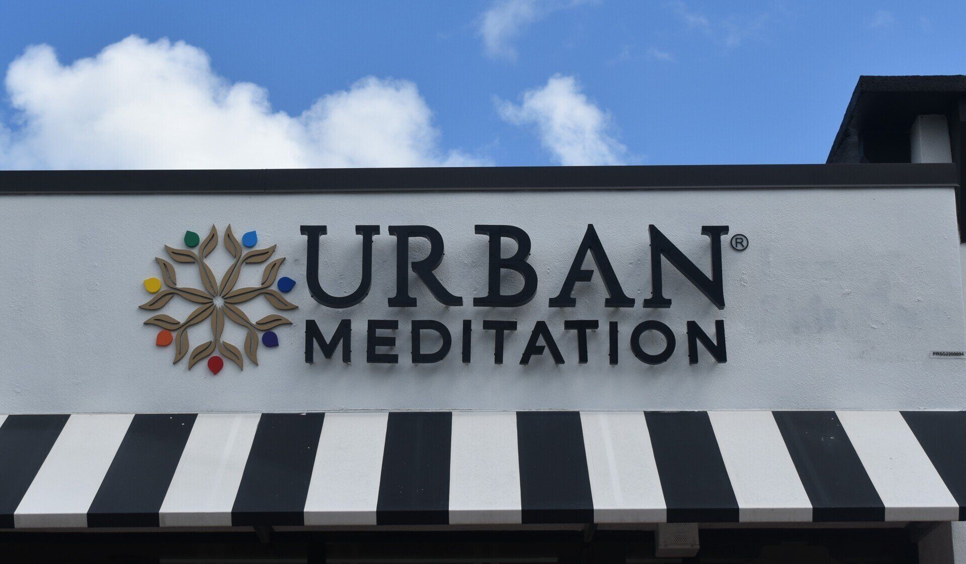 A sign for urban meditation with a black and white awning