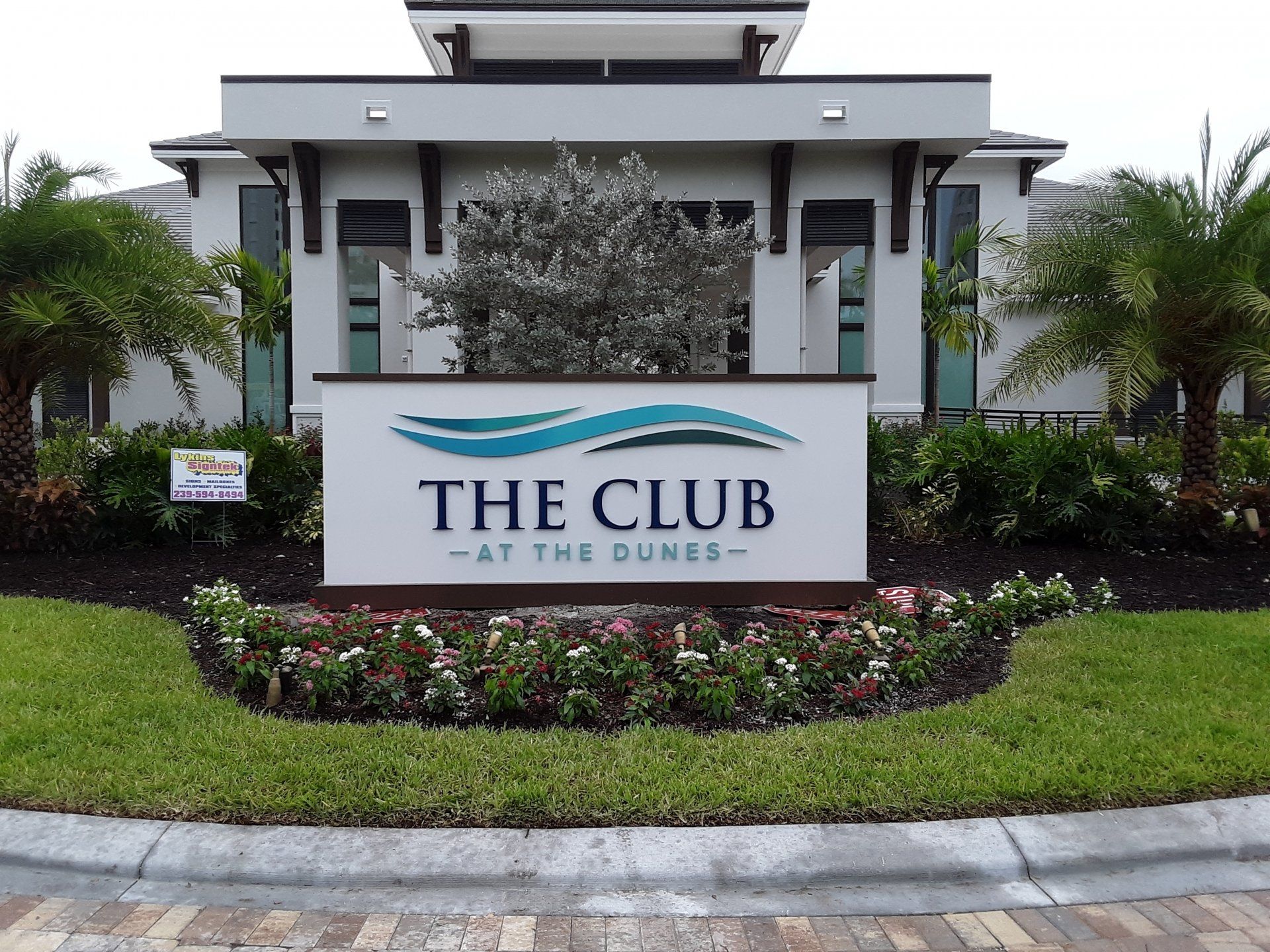 A sign for the club at the dunes is in front of a building