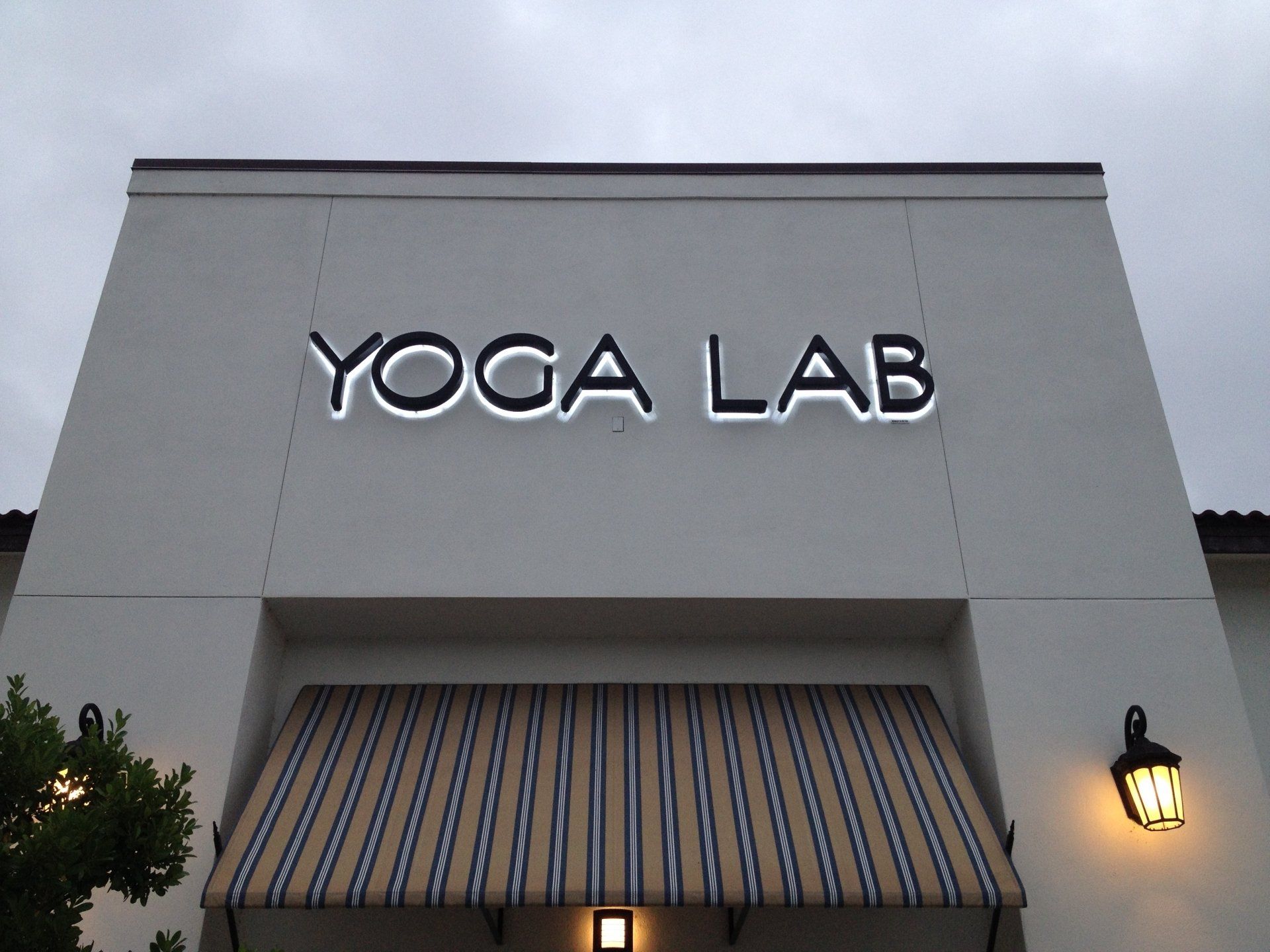 The front of a yoga lab building with a striped awning
