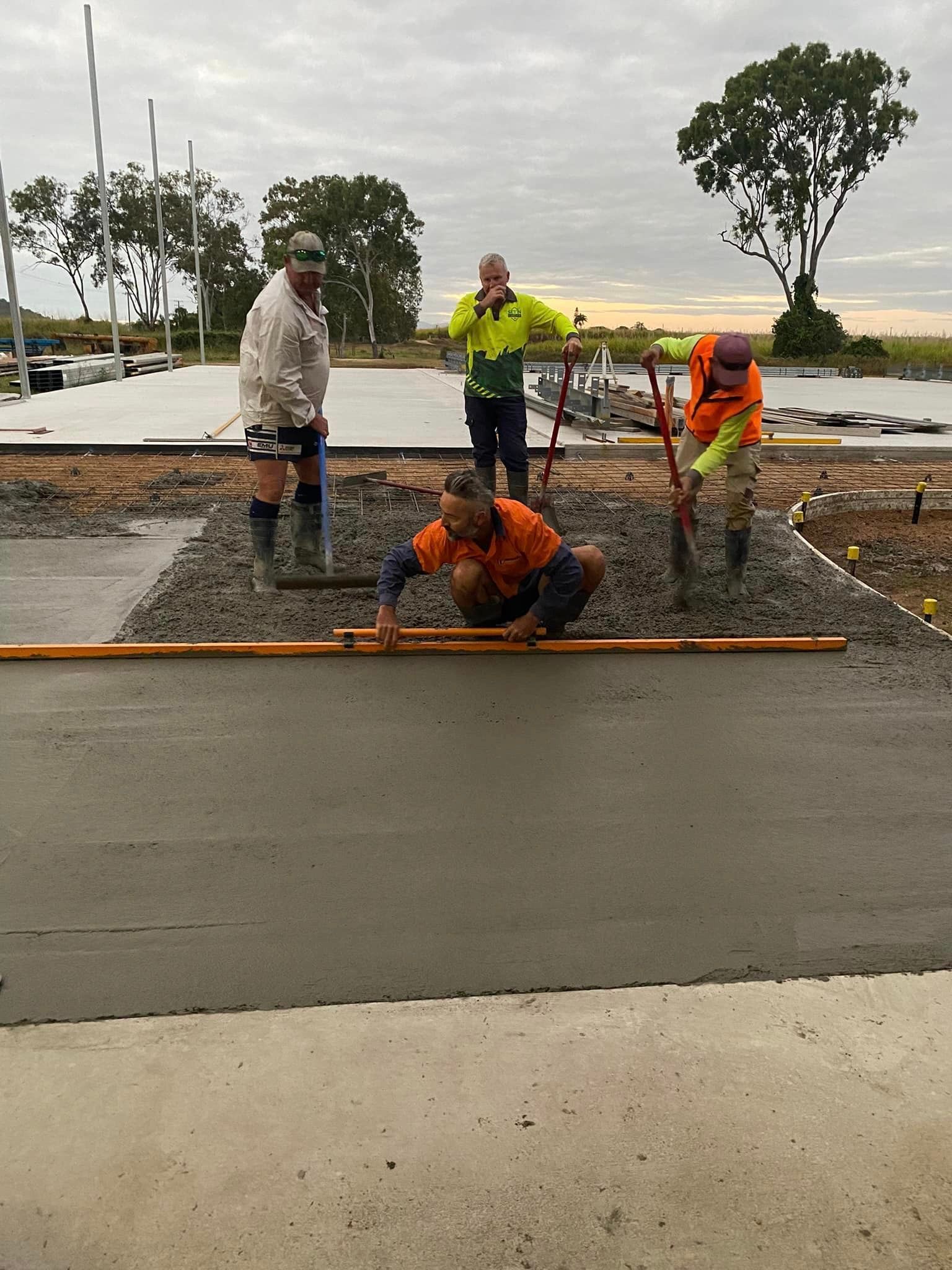 A Group of Construction Workers Are Working on A Concrete Floor — Fallon Constructions NQ in Fredericksfield, QLD