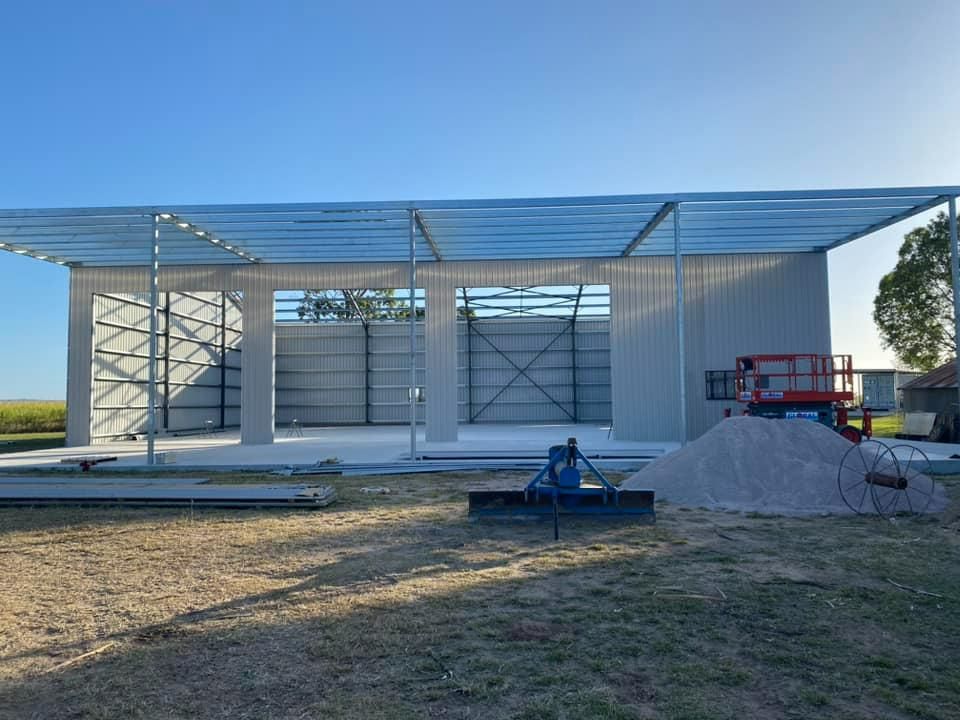 A Building Is Being Built in A Field with A Pile of Dirt in Front of It — Fallon Constructions NQ in Fredericksfield, QLD