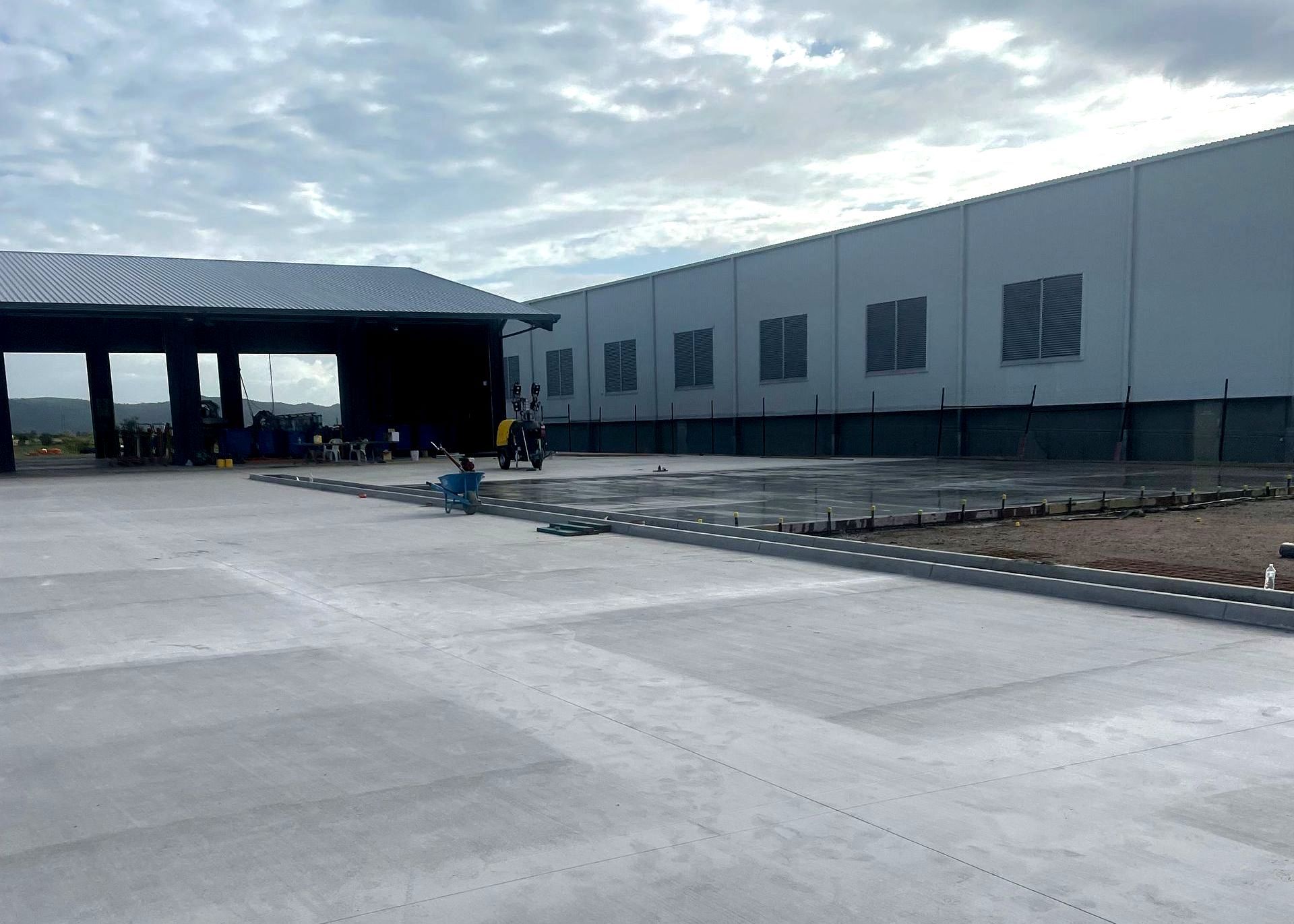 Collaborative Team of Builders Pouring Cement at Construction Site — Fallon Constructions NQ in Fredericksfield, QLD