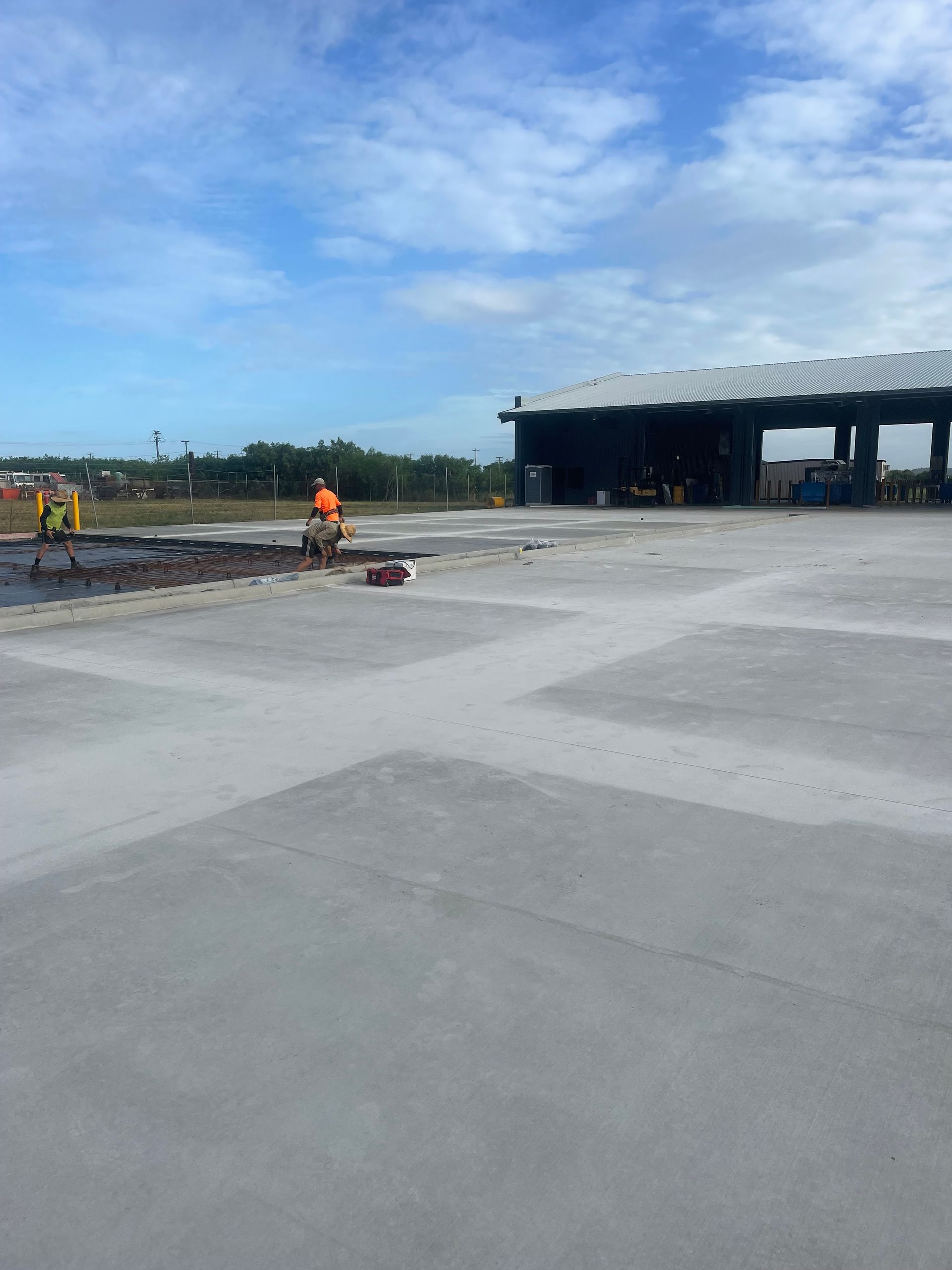 Worker levelling concrete slab during construction — Fallon Constructions NQ in Fredericksfield, QLD