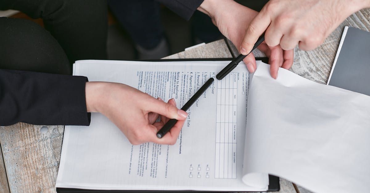 A person is holding a pen over a piece of paper.