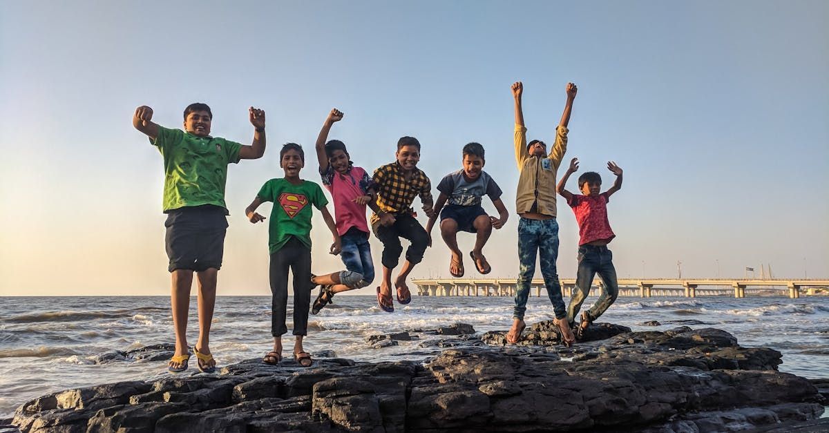 Group of teens at the beach jumping joyfully in the air