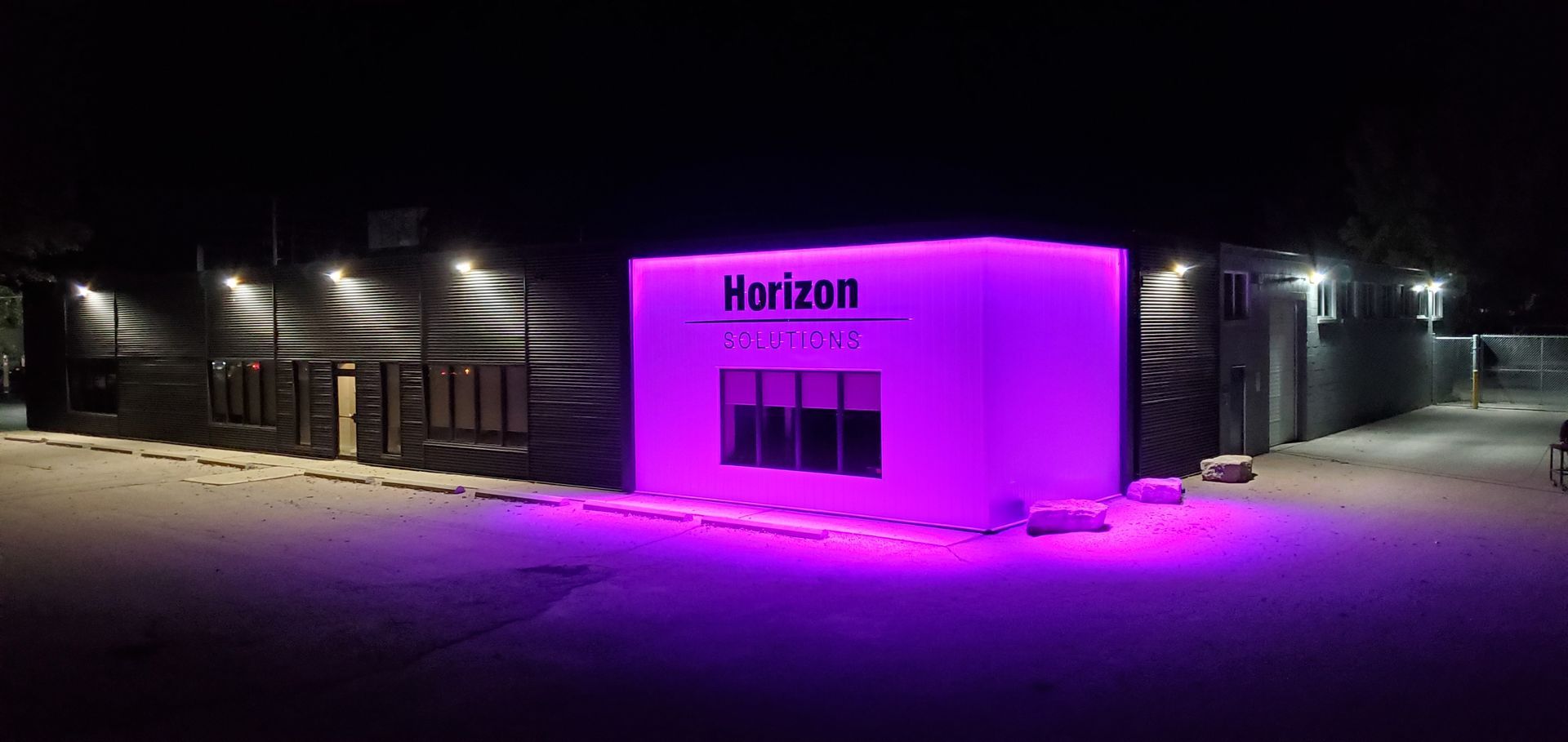 Horizon Solutions office building lit up in purple at night.