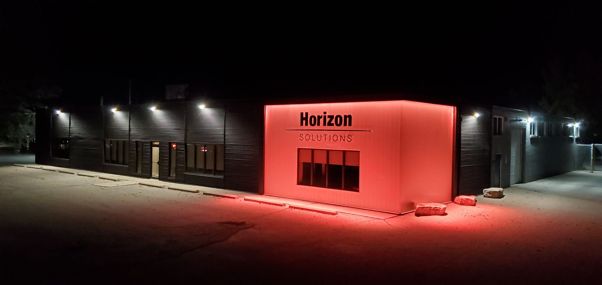 Horizon Solutions office building lit up in red at night.