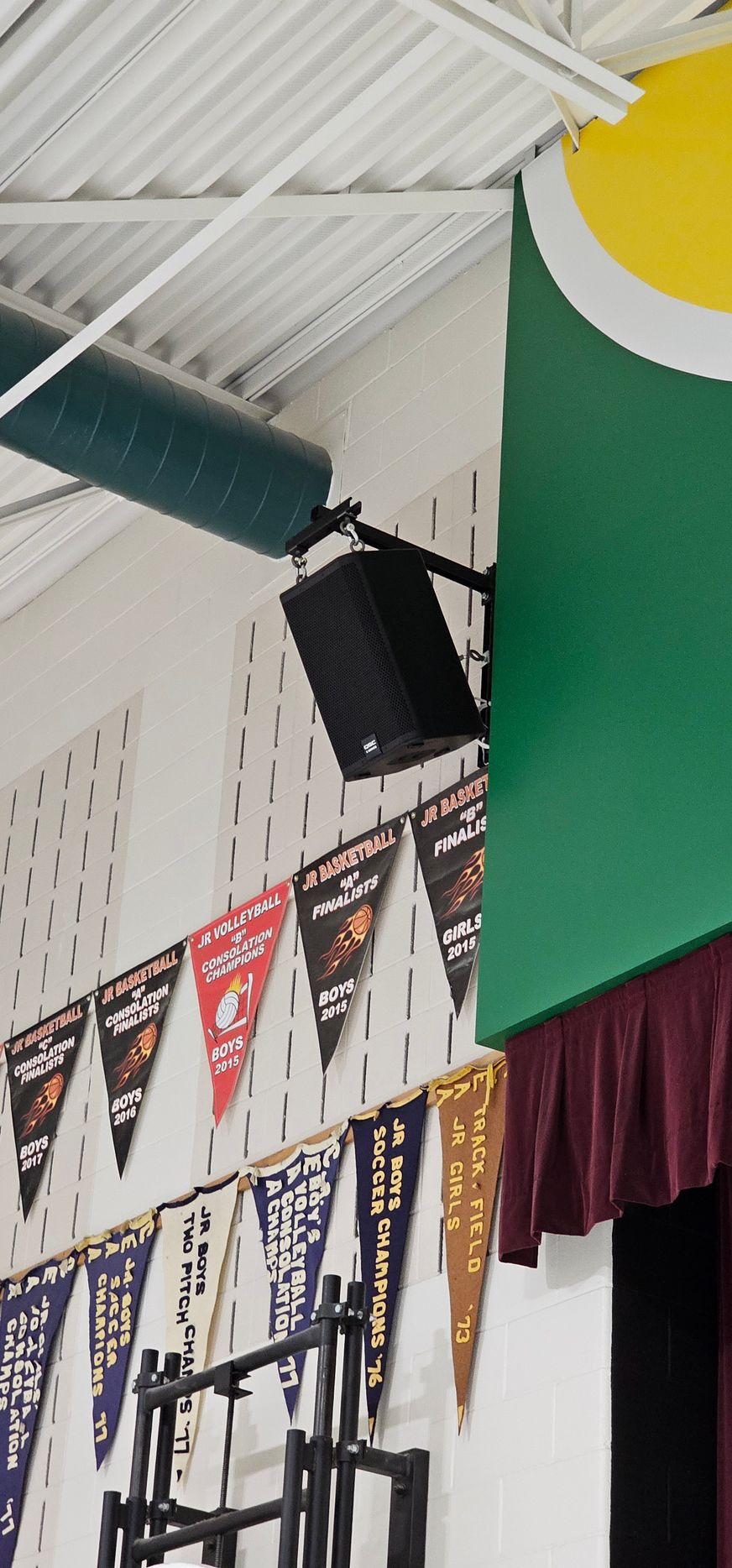 A bunch of flags are hanging from the ceiling in a gym
