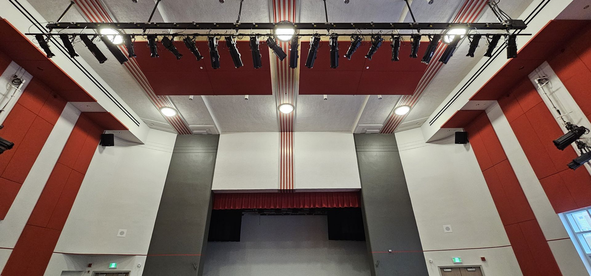 A large auditorium with red and white stripes on the walls and ceiling.