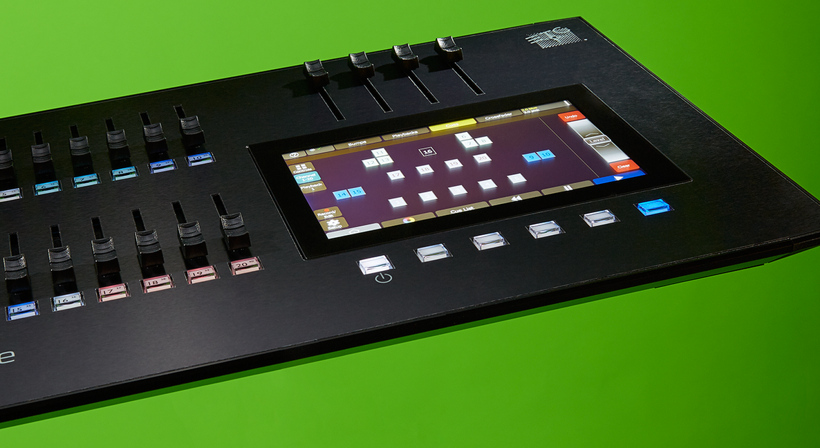 A black electronic device with a screen on it is sitting on a green surface.