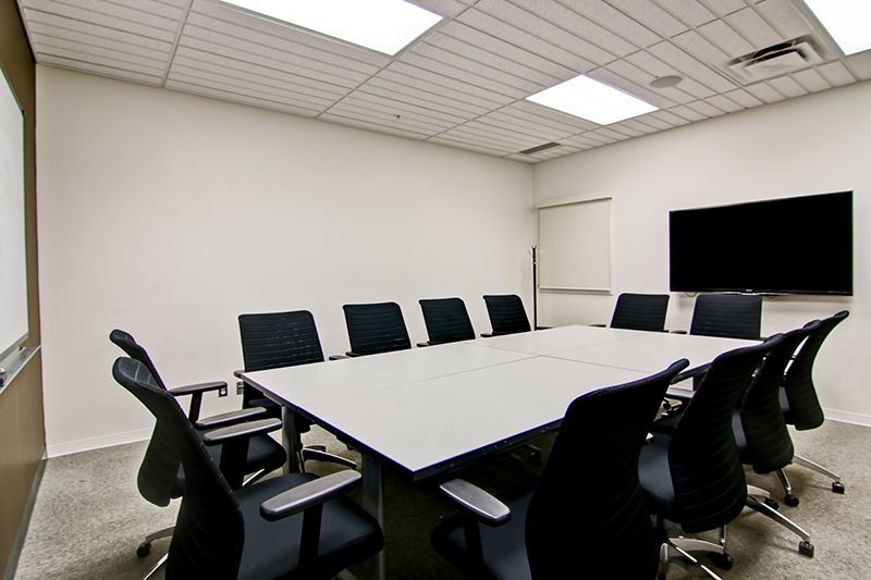 A conference room with a large flat screen tv on the wall