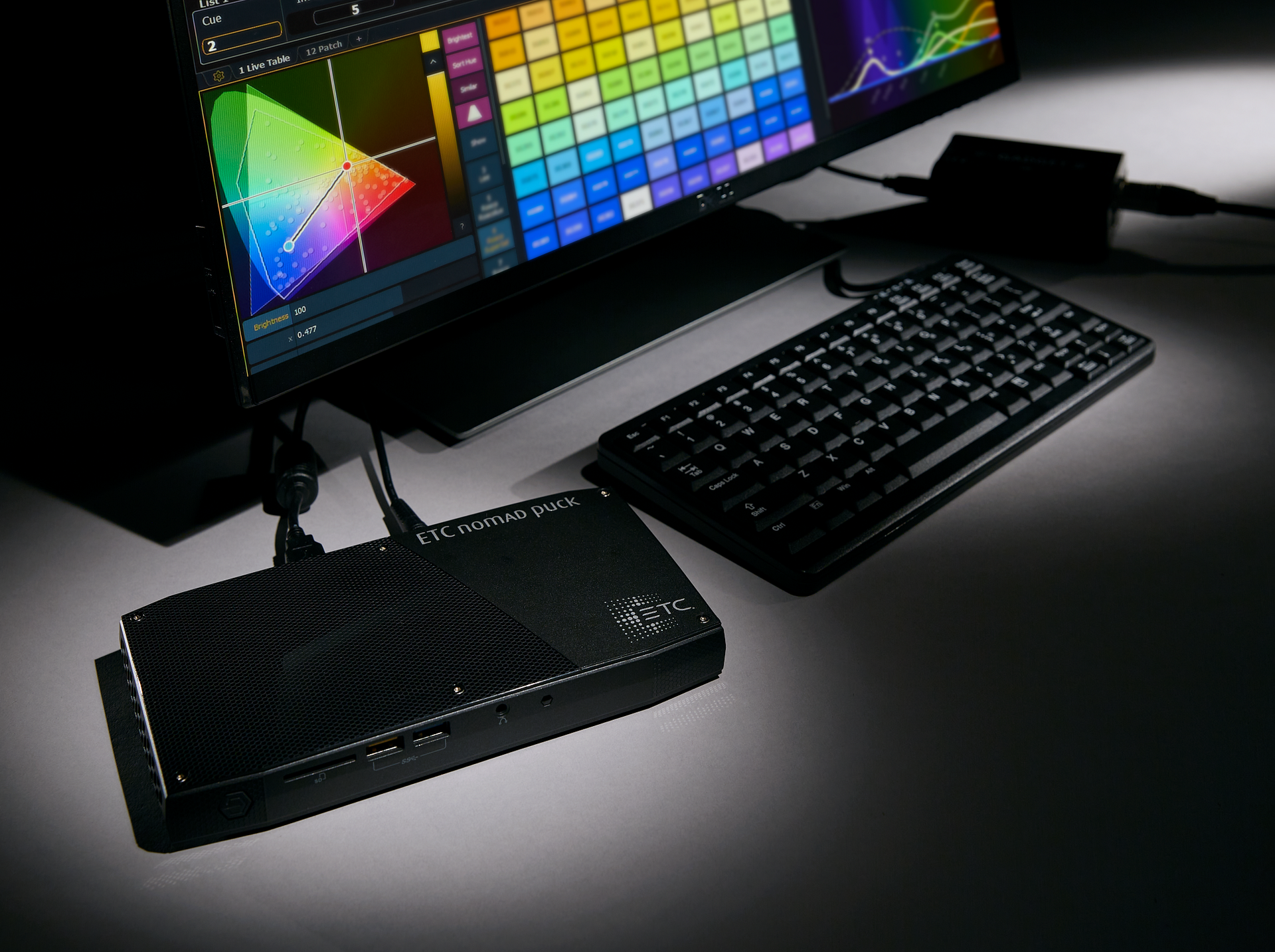 A computer monitor and keyboard are on a table