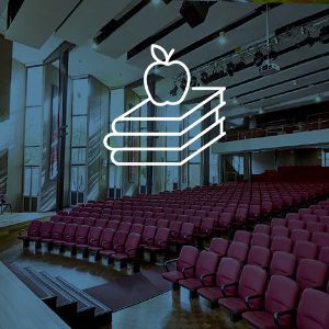 An auditorium with a stack of books and an apple on top of them.