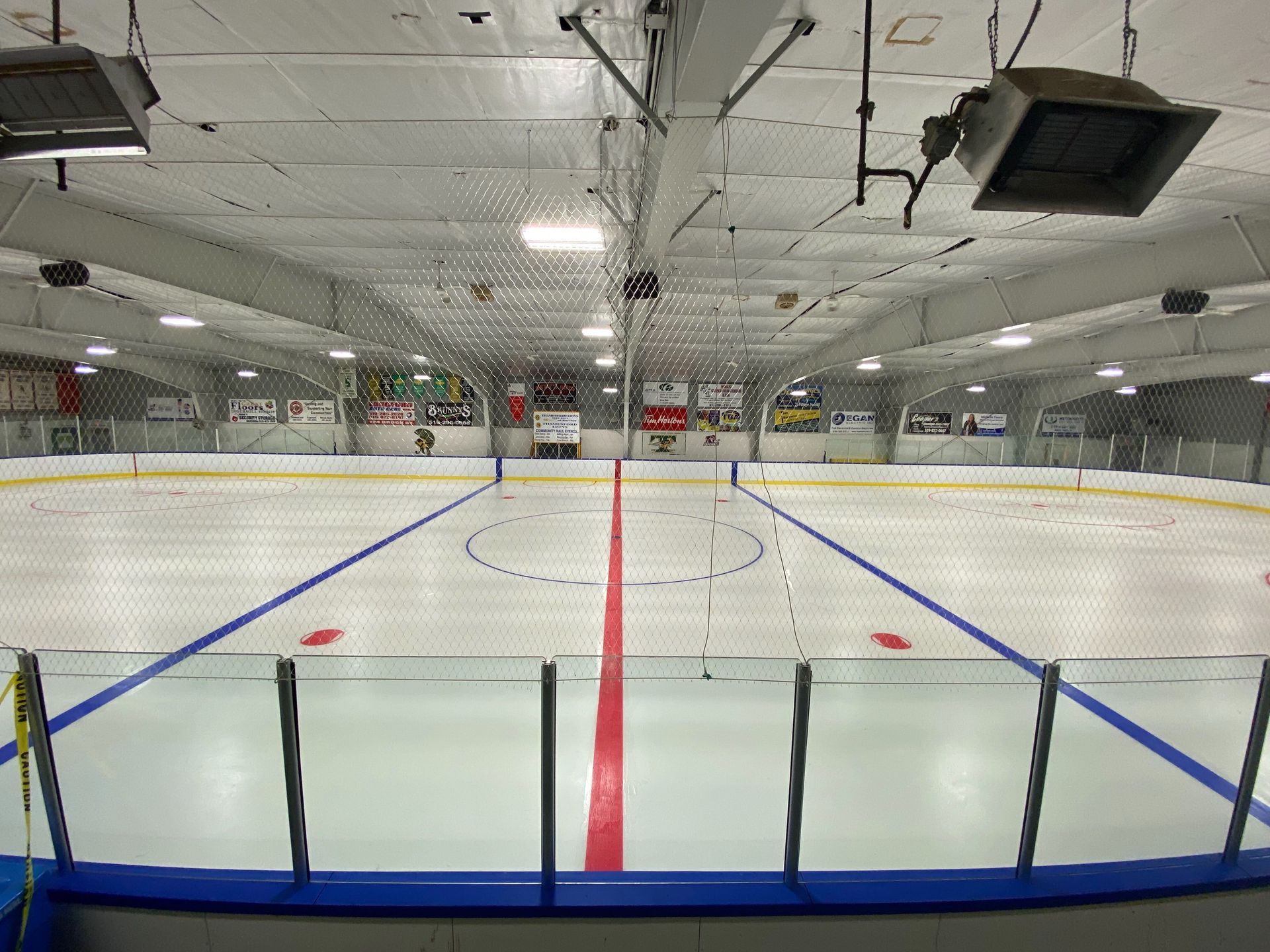 A large indoor ice rink with a red line on the ice.