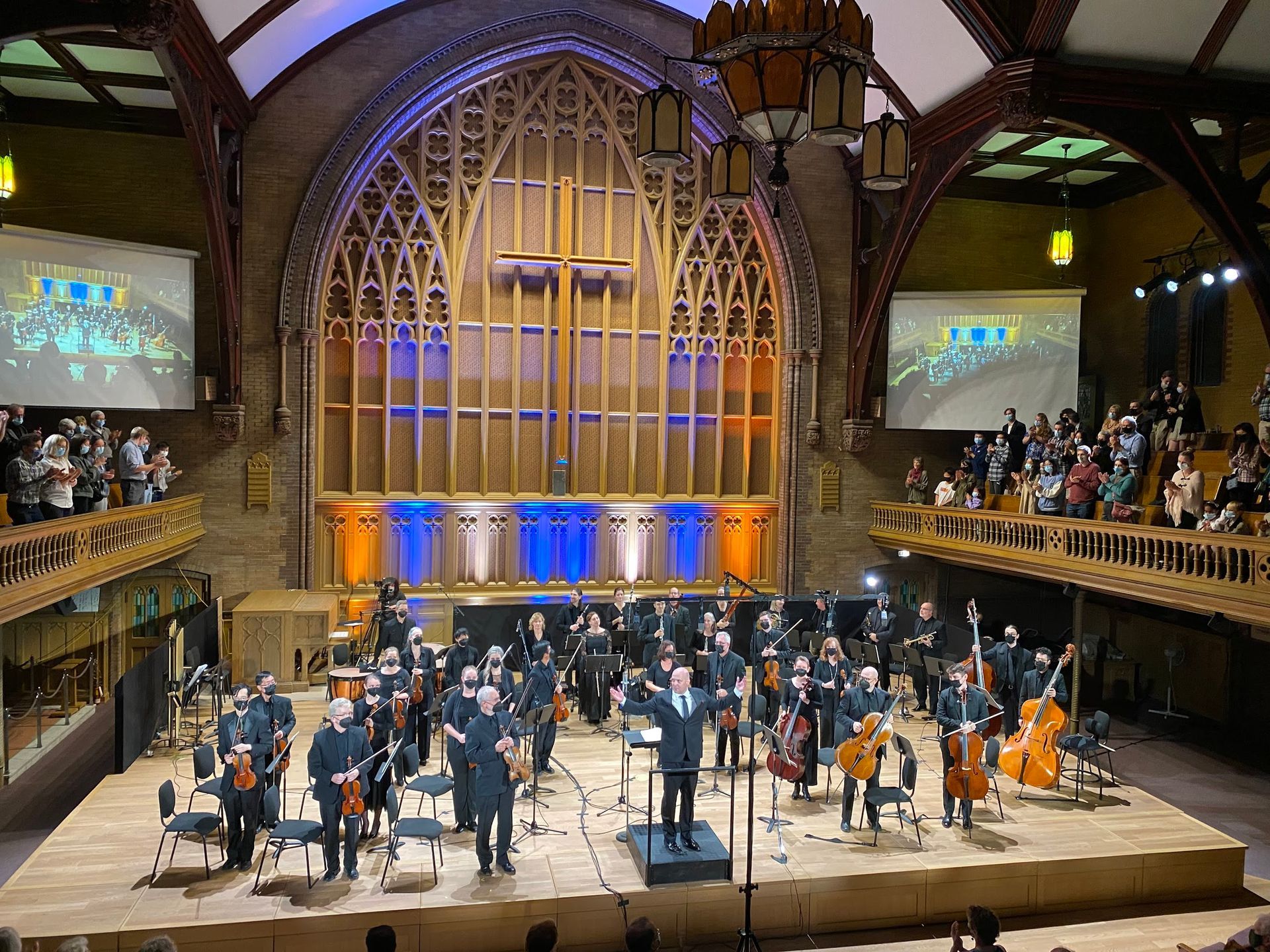 A large orchestra is playing in a large auditorium.