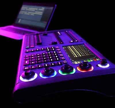 A laptop is sitting on top of a purple control panel.