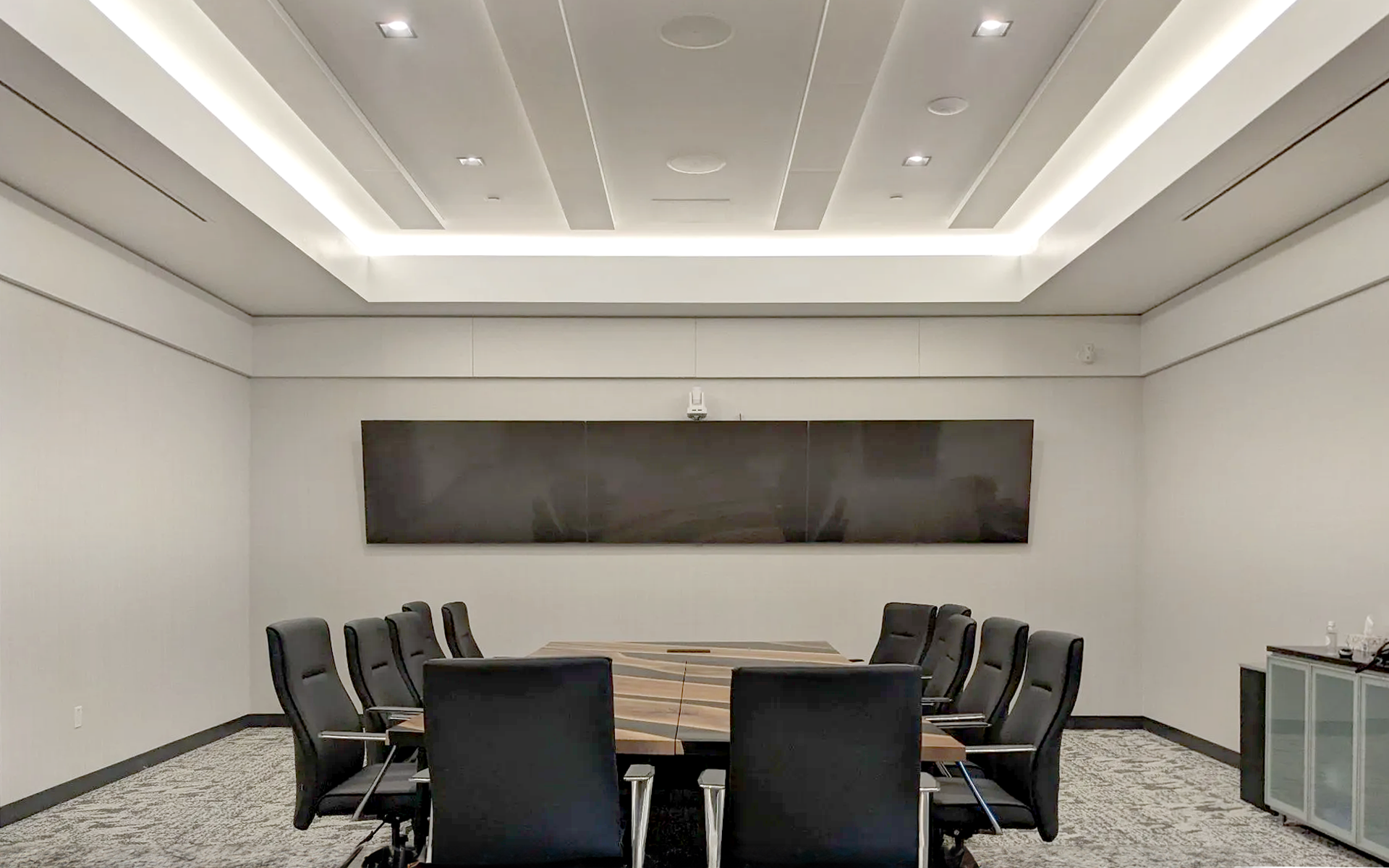 A conference room with a long table and chairs.