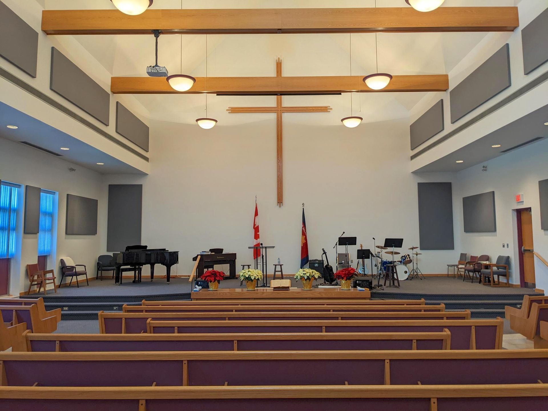 An empty church with a cross hanging from the ceiling