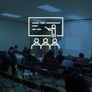 A man is giving a presentation to a group of people in a classroom.