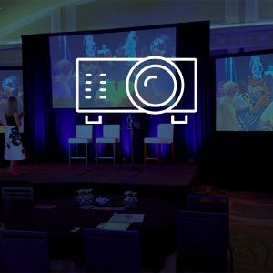 A woman is standing on a stage in front of a projector screen.