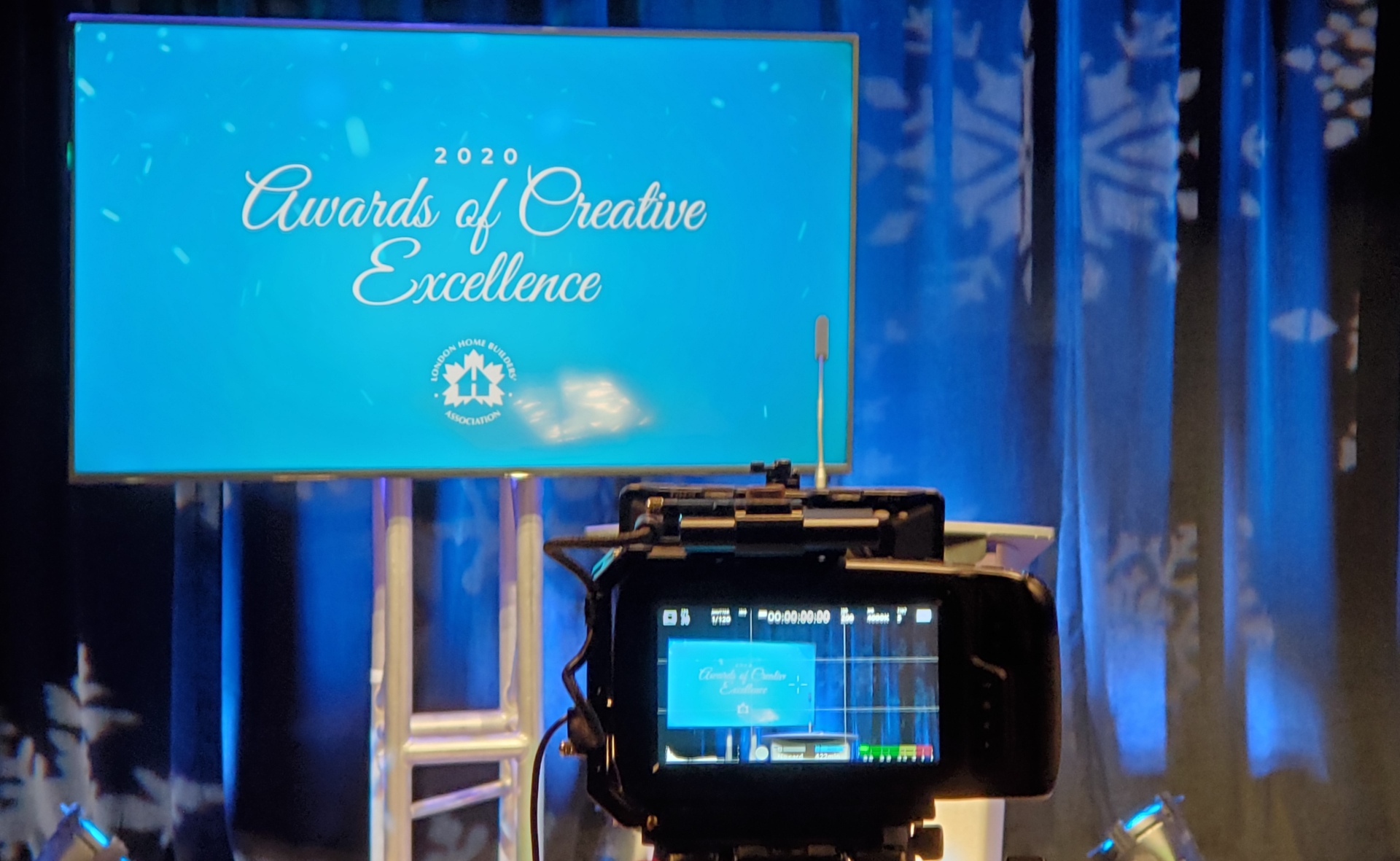 A camera is sitting in front of a screen that says awards of creative excellence.