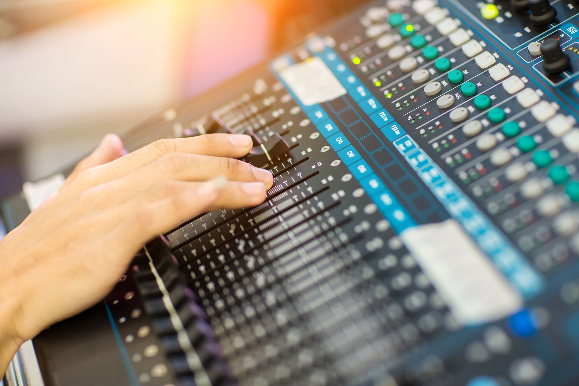 A person is using a sound mixer in a studio.