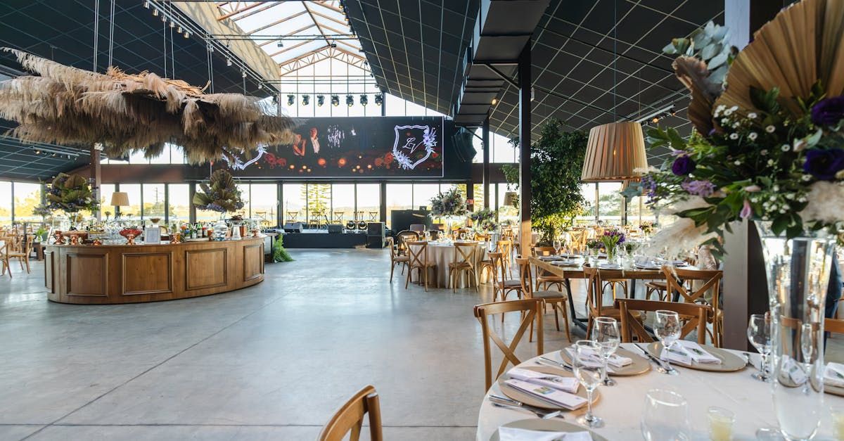 A large room with tables and chairs set up for a wedding reception.