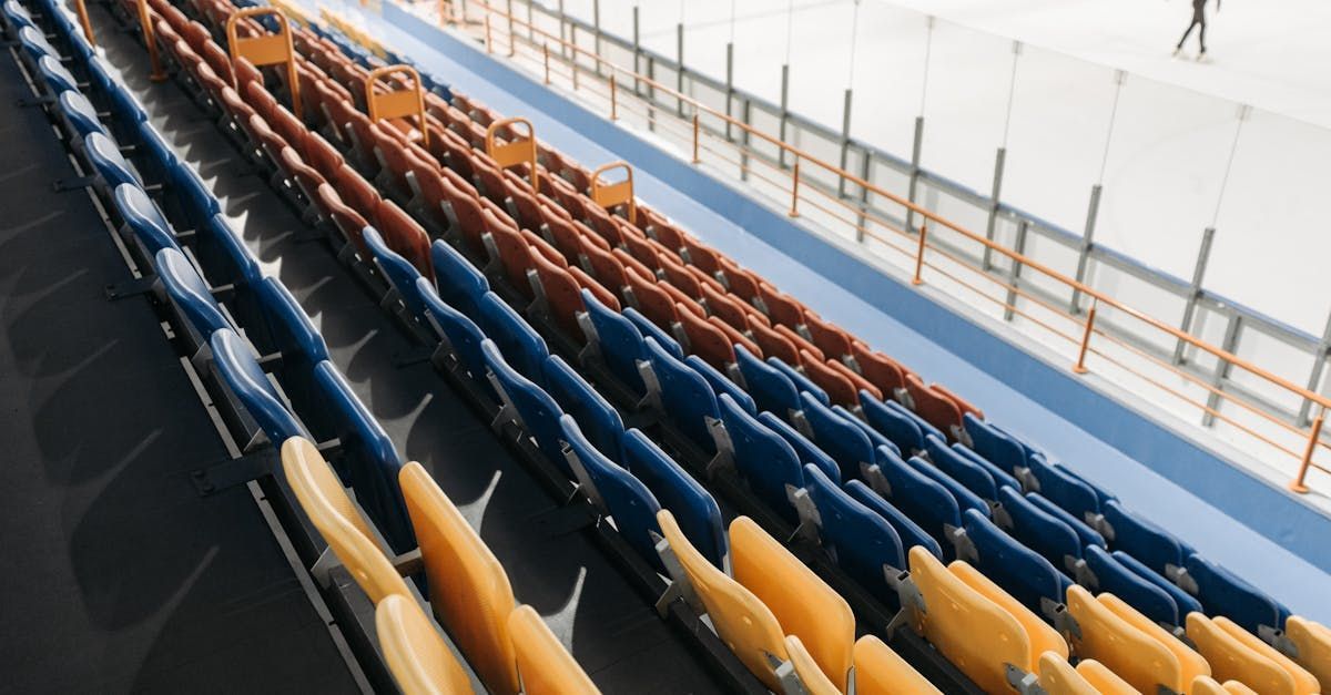 A row of blue and orange seats in a stadium