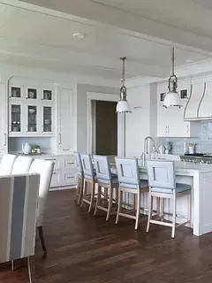 A kitchen with white cabinets and wooden floors