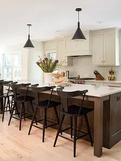 A kitchen with a large island and stools.