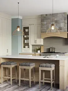 A kitchen with a large island , stools , and a stove.