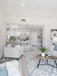 A living room with a couch , chair , coffee table and rug.