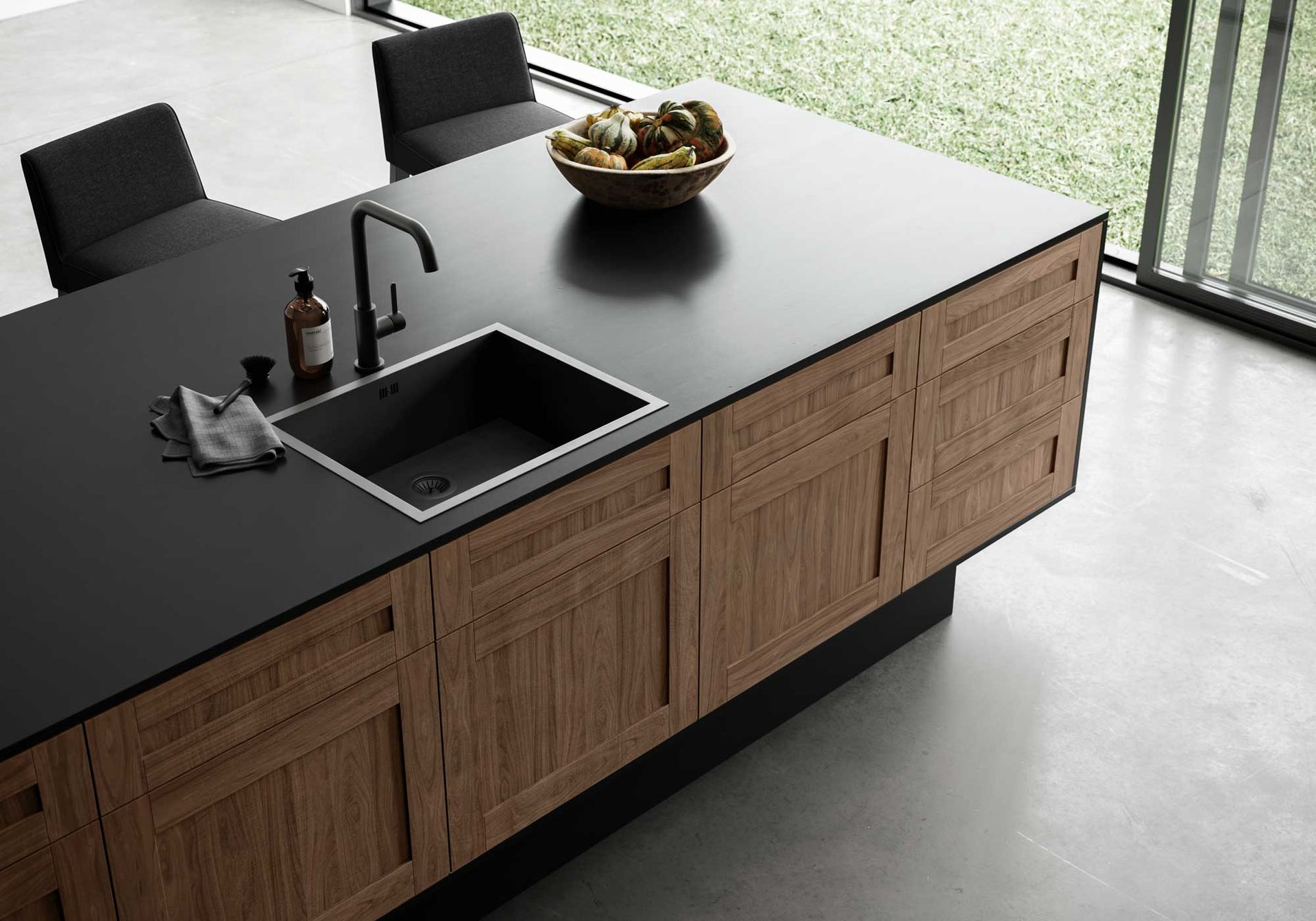 A kitchen with a sink and a bowl of fruit on the counter
