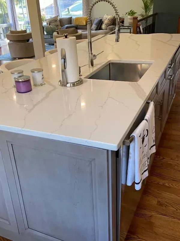 A kitchen island with a sink and a paper towel holder.