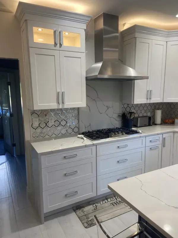 A kitchen with white cabinets and stainless steel appliances.
