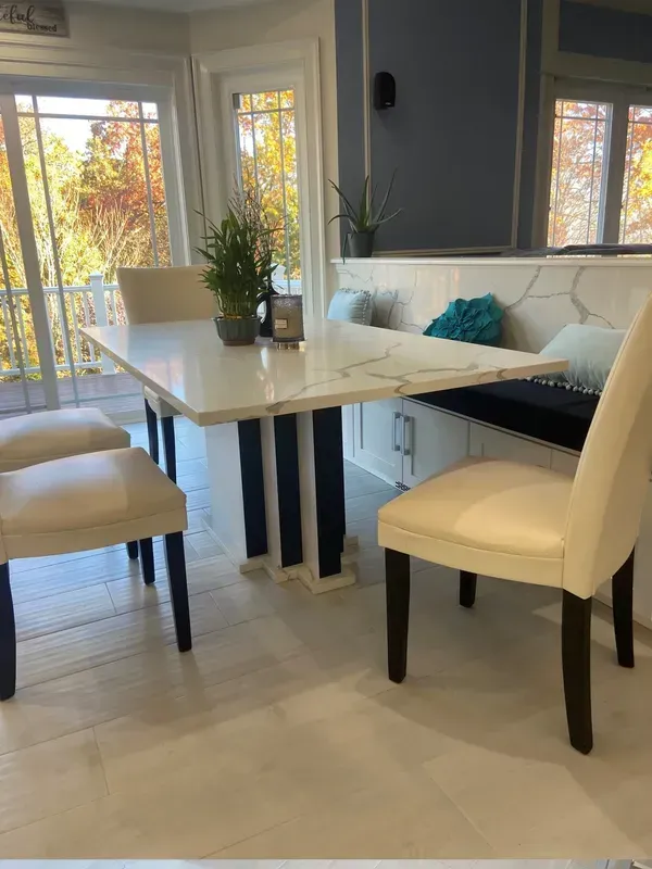 A dining room with a table and chairs and a bench.