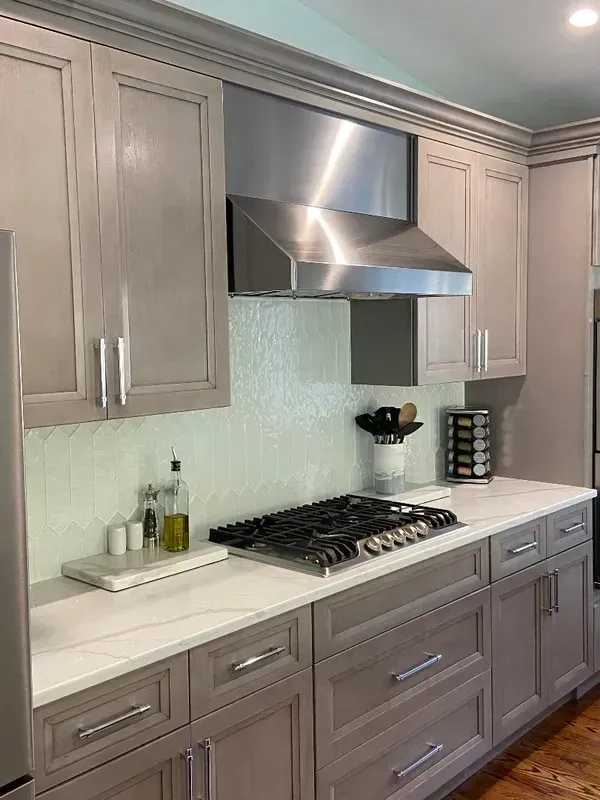 A kitchen with gray cabinets and stainless steel appliances.