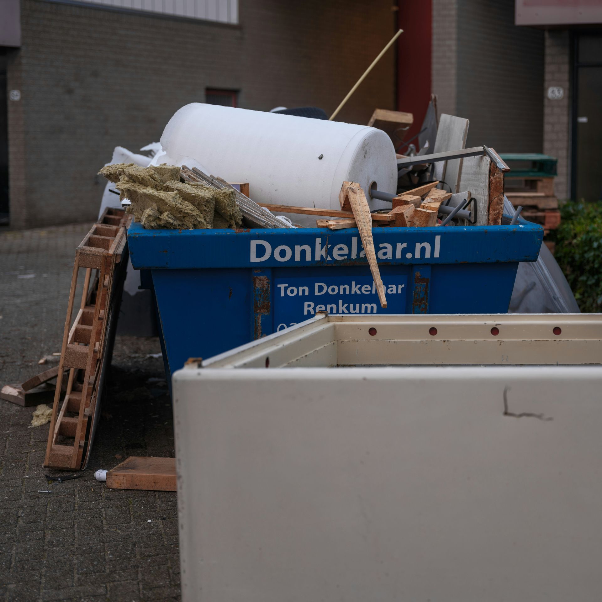 blue skip bins with rubbish on top